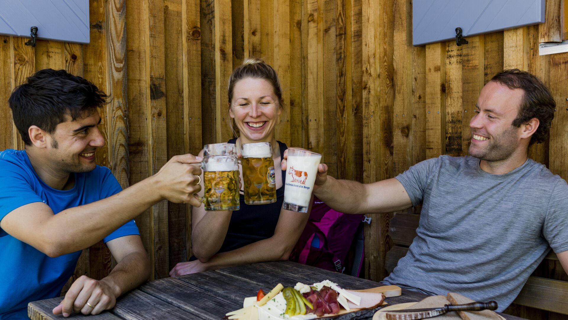 Auf der Hütte: Drei Personen stoßen mit Bierkrügen an | © DAV/Hans Herbig